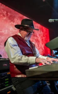 SST_CMC_Keyboards_v2a Keyboard player in a black cowboy hat and red leather vest performing with the Silver Star Band